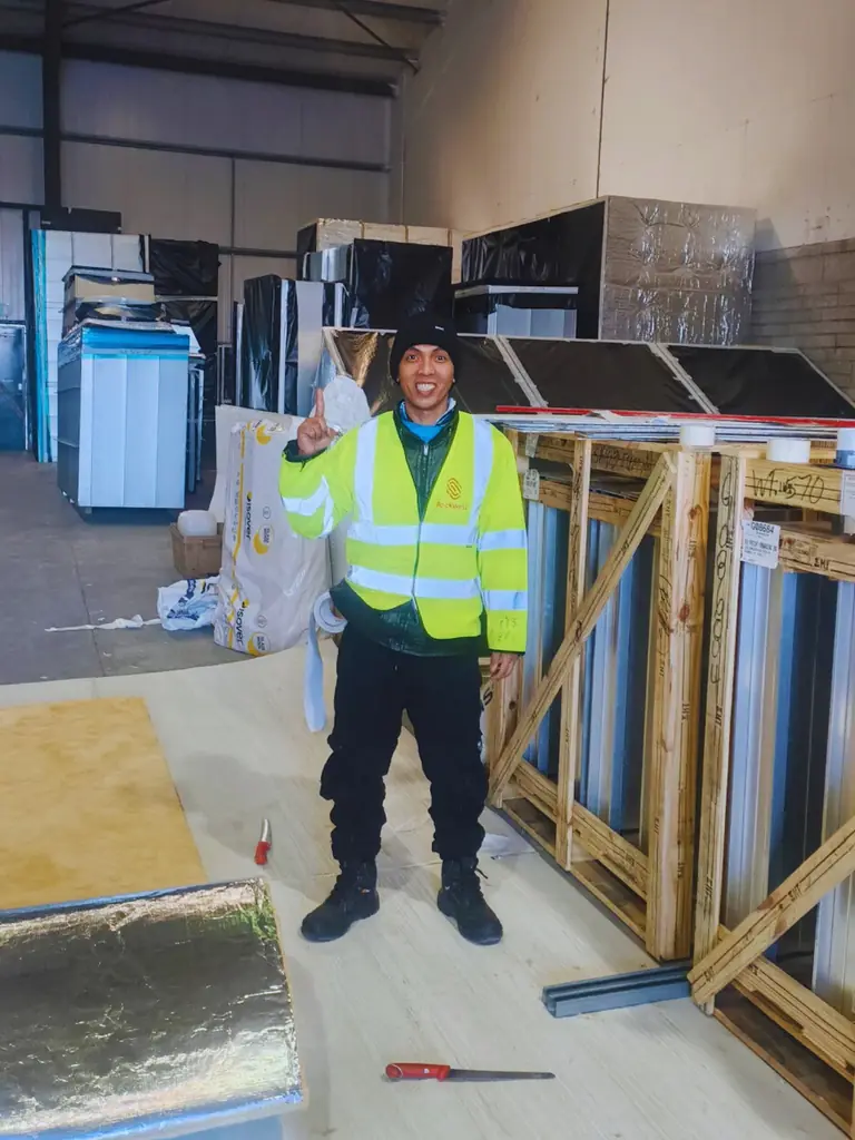 Worker in a high-visibility jacket inside a workshop