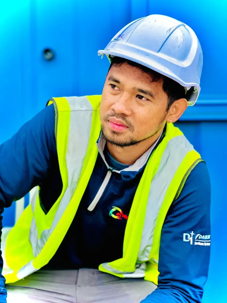 Skilled worker wearing a white hard hat and high-visibility vest
